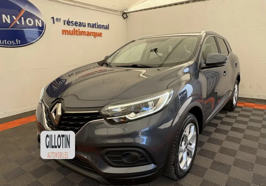 Renault Kadjar Intens gris foncé en 3/4 avant droit, avec phares LED et jantes alliage visibles en intérieur showroom.