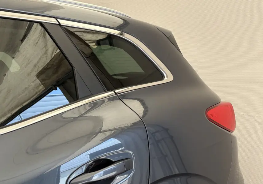 Vue latérale arrière côté droit du Renault Kadjar gris foncé, mettant en valeur la poignée de porte et le feu arrière.