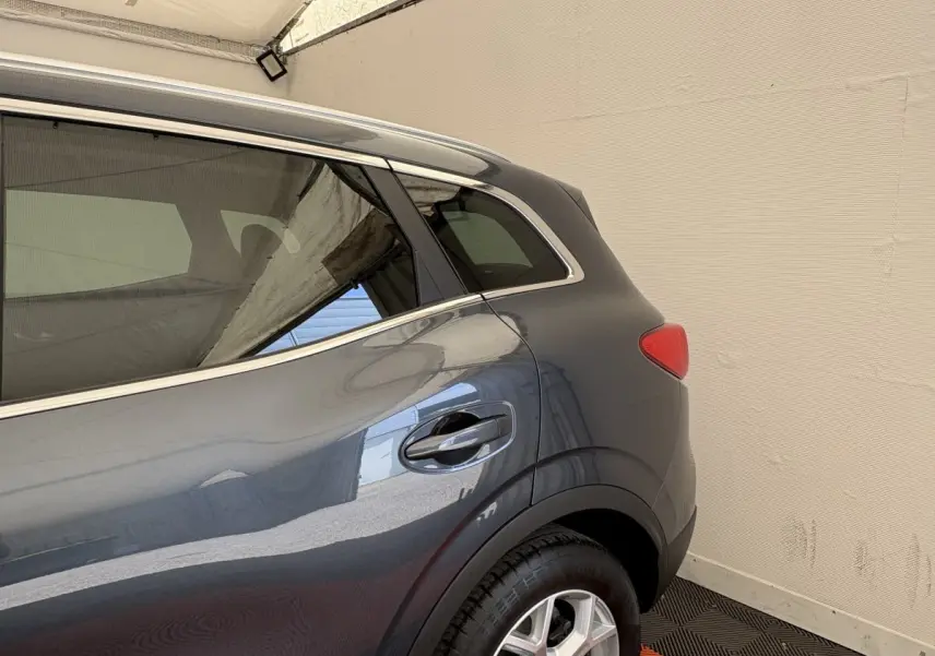 Vue côté arrière droit du Renault Kadjar Intens gris foncé, mettant en valeur la porte et le feu arrière.