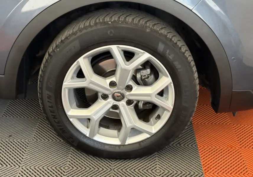 Gros plan sur la roue avant gauche gris foncé du Renault Kadjar Intens avec jante alliage à cinq branches doubles.