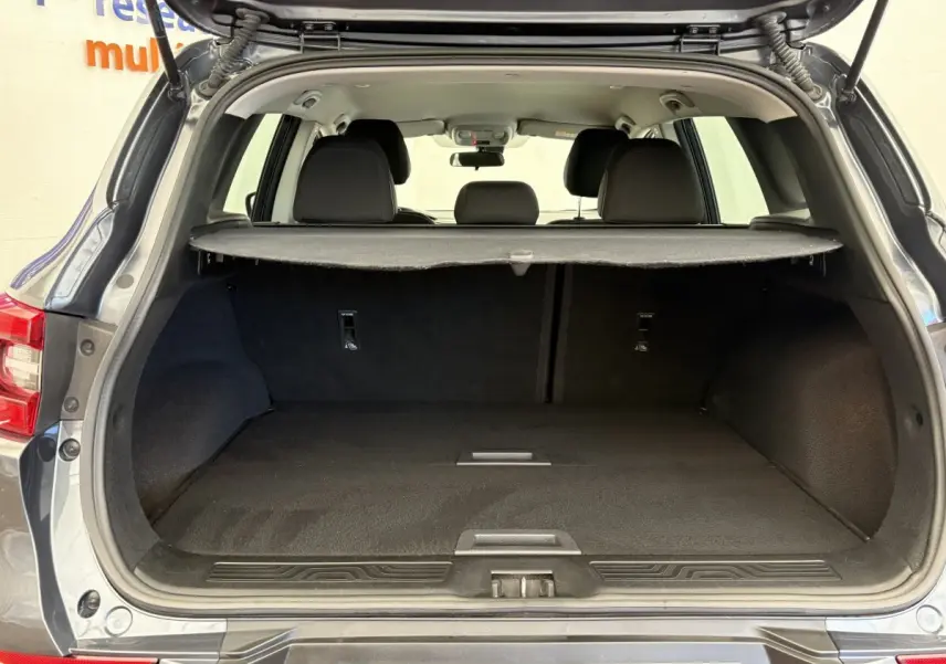 Coffre ouvert d’un Renault Kadjar Intens gris foncé, vue arrière montrant l’espace de chargement et la tablette cache-bagages.