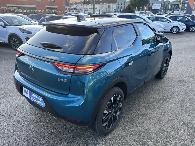 Vue 3/4 arrière droite d'une DS3 bleu métallisé avec toit noir et feux arrière LED distinctifs.