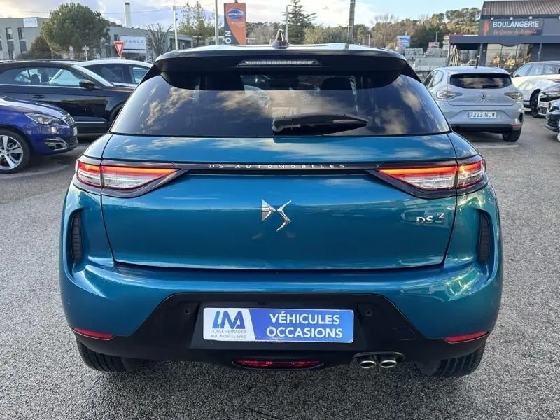 Vue arrière d'une DS3 bleu métallisé avec feux LED et double sortie d'échappement visible en concession.
