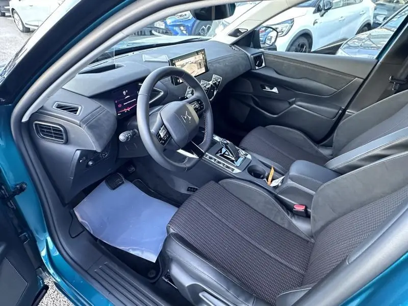 Intérieur avant droit de la DS3 1.2 Hybride bleu 2025, avec tableau de bord numérique et sellerie noire Alcantara.