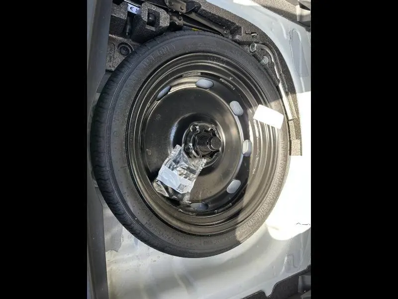 Roue de secours noire montée dans le coffre d'une CUPRA Formentor 2025 blanc Nevada métallisé, vue en plongée.