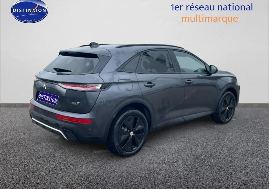 DS7 gris titane vue 3/4 arrière droit, jantes noires et feux arrière LED allongés visibles.