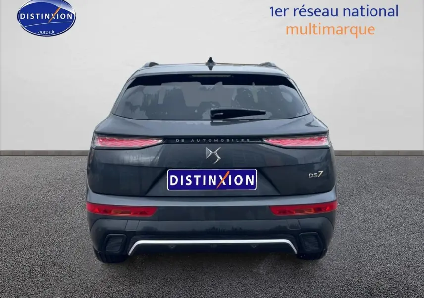 Vue arrière d'un DS7 gris titane avec feux LED fins et double sortie d'échappement intégrée au pare-chocs.