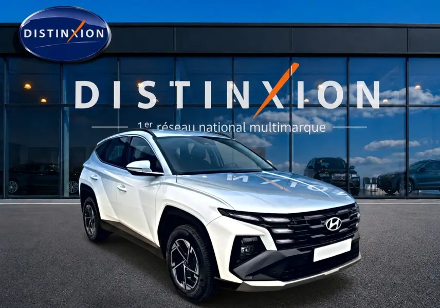 Hyundai Tucson blanc 2026 en 3/4 avant droit, avec calandre noire et jantes alliage 17 pouces.