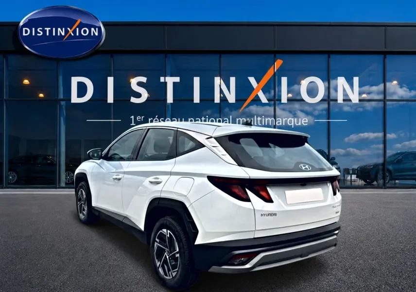 Vue 3/4 arrière droite du Hyundai Tucson blanc 2026 avec jantes alliage et feux arrière LED distinctifs.