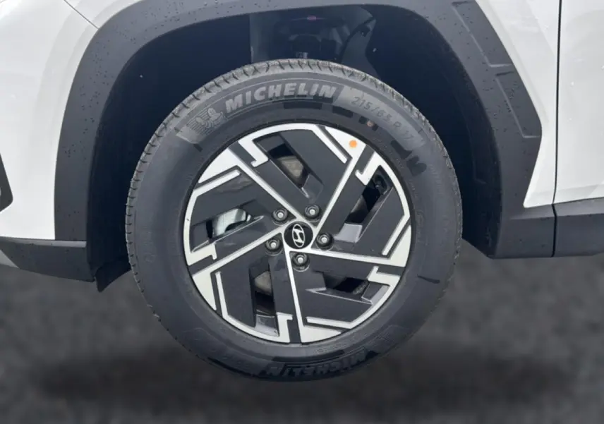 Gros plan sur la roue avant gauche blanche du Hyundai Tucson 2026 avec jante alliage noire et argentée Michelin.