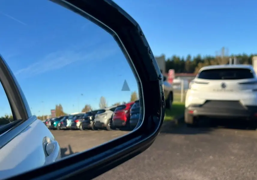 Vue latérale droite d'une BMW Série 1 blanche alpin, avec jantes bicolores en Y visibles au soleil.