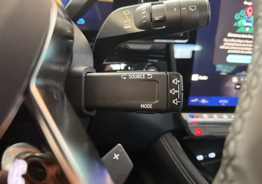 Gros plan sur la commande multimédia au volant du Renault Austral E-Tech 200, intérieur noir avec écran tactile visible.