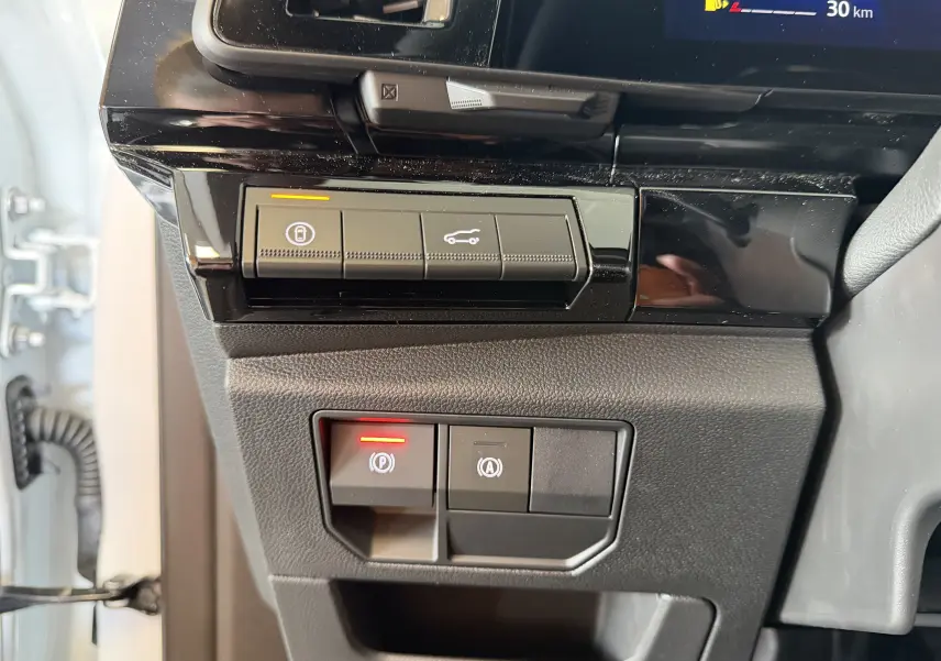 Vue rapprochée des commandes de verrouillage et ouverture du coffre sur le tableau de bord noir du Renault Austral E-Tech.