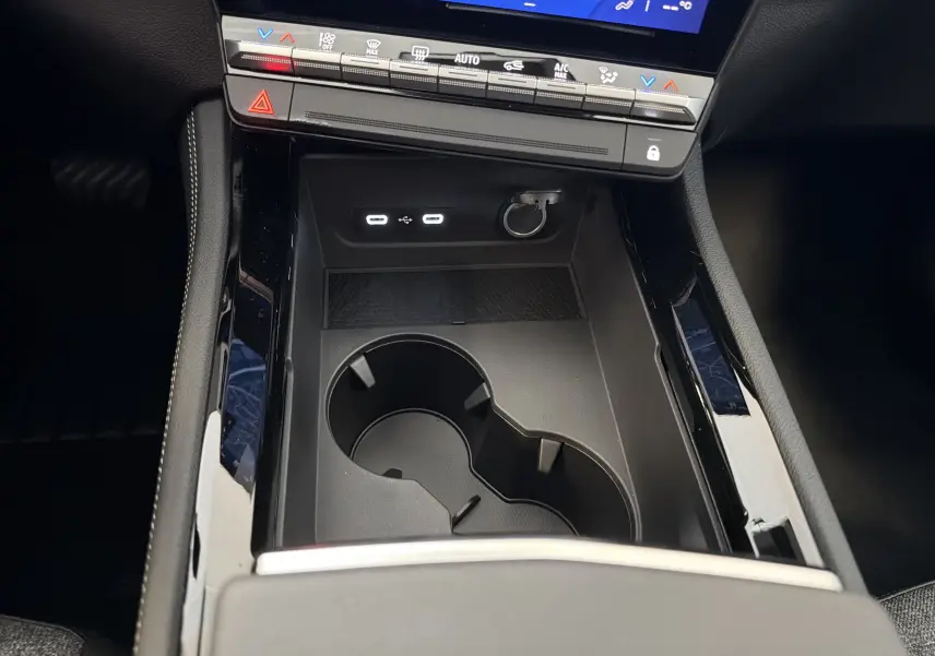 Gros plan sur la console centrale noire du Renault Austral E-Tech 200, montrant les ports USB et porte-gobelets.