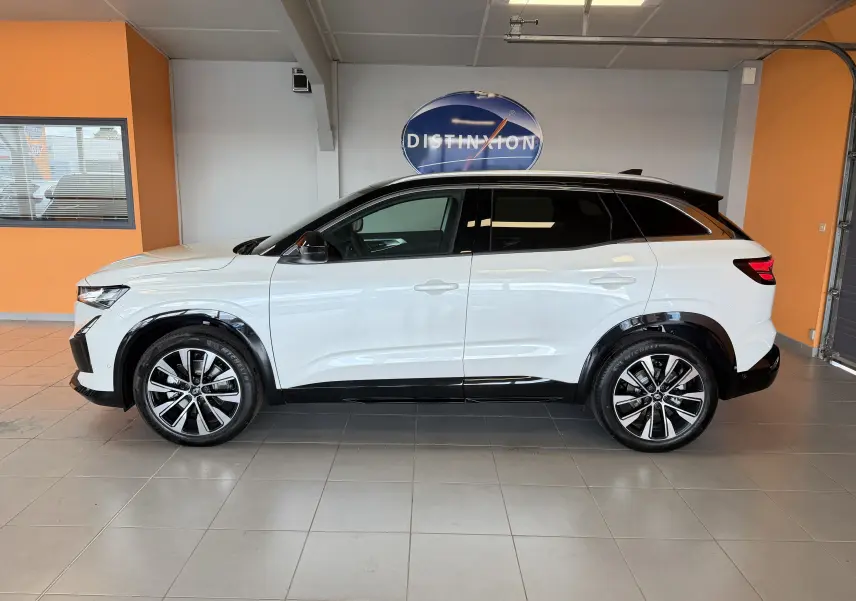 Vue de profil droit du Renault Austral E-Tech 200 Full Hybrid blanc toit noir avec jantes alliage 19 pouces en showroom.