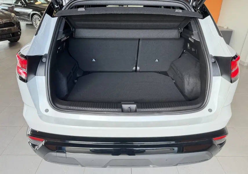 Vue arrière du coffre ouvert d'un Renault Austral E-Tech 200 blanc toit noir, montrant l'espace de chargement vide.