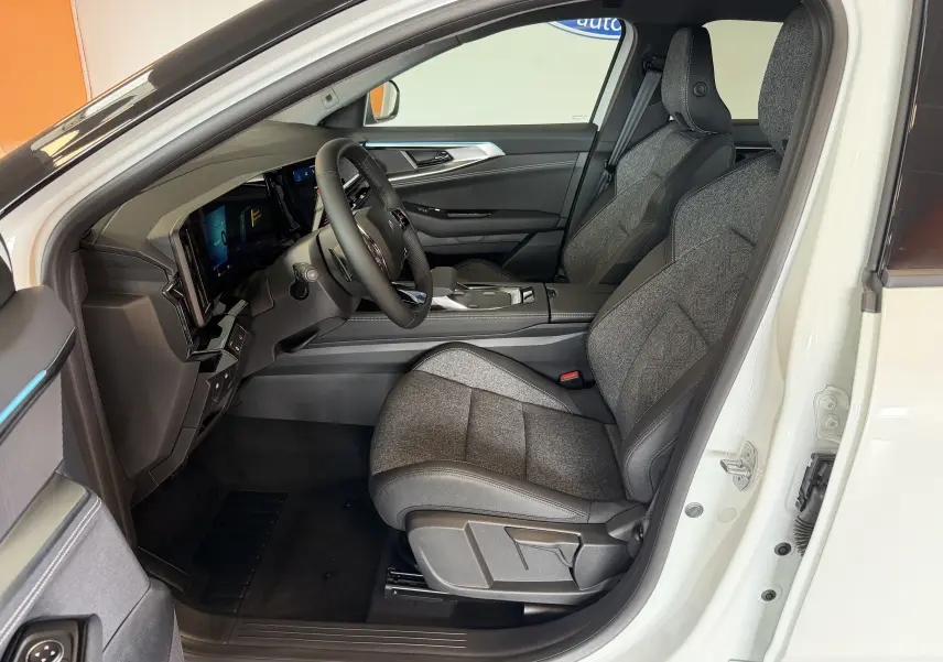 Vue intérieure côté conducteur du Renault Austral E-Tech 200 blanc toit noir, sièges gris tissu et similicuir avec surpiqûres.