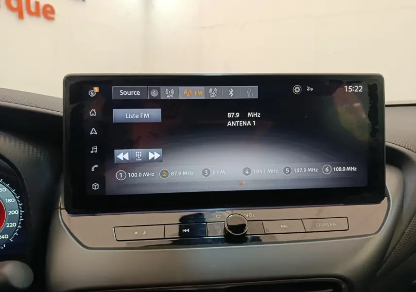 Écran tactile central affichant la radio FM dans l'habitacle du Nissan Juke gris clair, vue de face.
