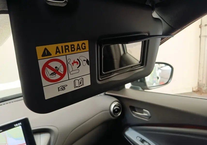 Vue intérieure côté conducteur du Nissan Juke gris clair 2025, avec pare-soleil ouvert et miroir intégré visible.