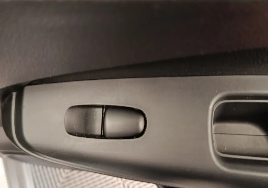 Détail du bouton de réglage du siège côté conducteur dans l'habitacle du Nissan Juke gris clair 2025.