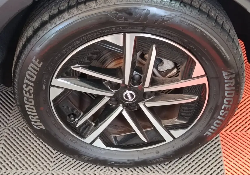 Gros plan sur la jante alliage bicolore et pneu Bridgestone du Nissan Juke gris clair, côté roue avant.