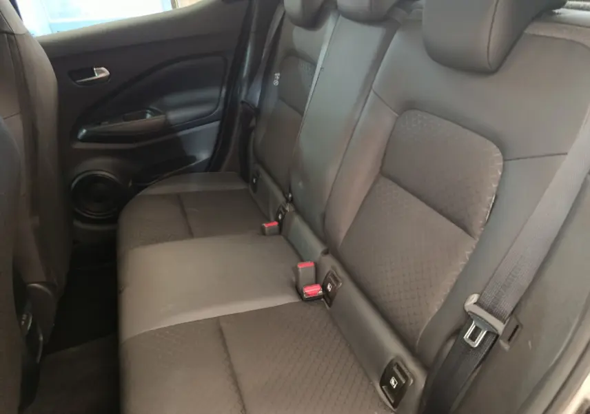 Vue intérieure côté droit des sièges arrière noirs du Nissan Juke 2025, avec ceintures et ancrages Isofix visibles.