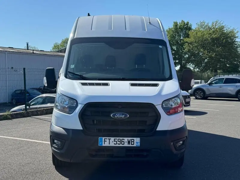 Vue de face d'un fourgon Ford Transit blanc glacier avec calandre noire et plaque d'immatriculation française visible