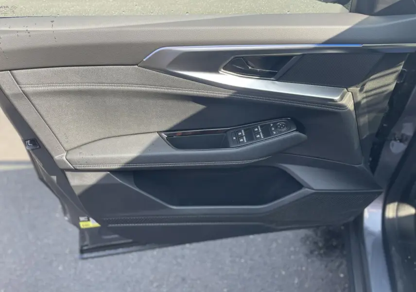 Gros plan sur la porte avant gauche gris foncé de la Renault Rafale 2025 avec commandes de vitres et poignée intégrée.