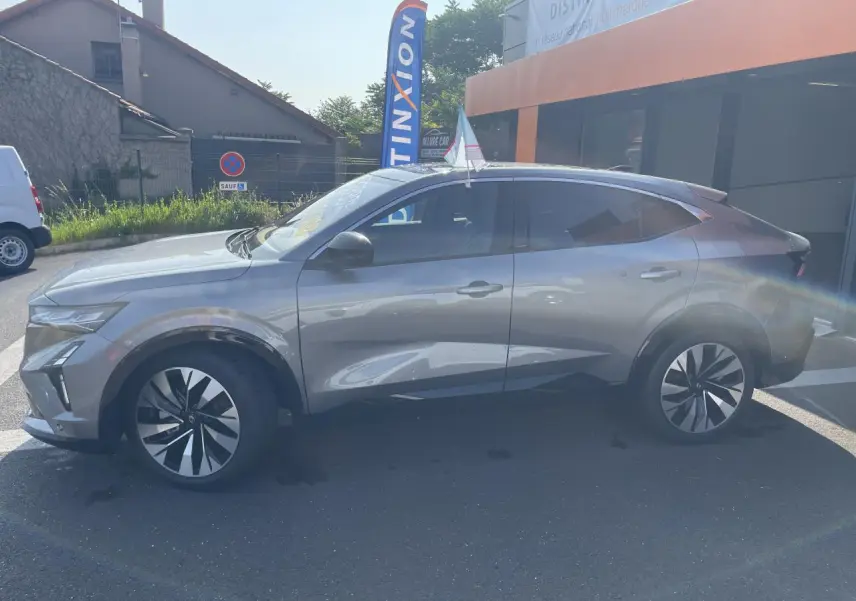 Renault Rafale gris avec toit noir vu de profil côté gauche, soulignant ses jantes modernes et lignes dynamiques.