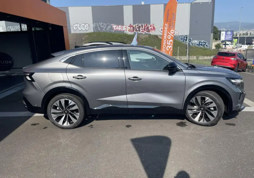 Profil côté gauche d'une Renault Rafale gris avec toit noir, jantes alliage et lignes sculptées modernes.