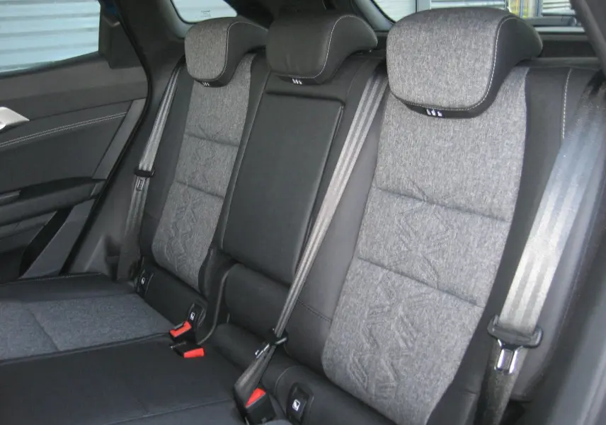 Vue intérieure sur la banquette arrière grise et noire du Renault Austral 2025 avec ceintures de sécurité visibles.