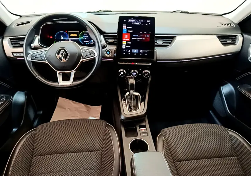 Vue intérieure avant du tableau de bord et volant de la Renault Arkana Techno E-Tech, avec écran tactile central vertical.