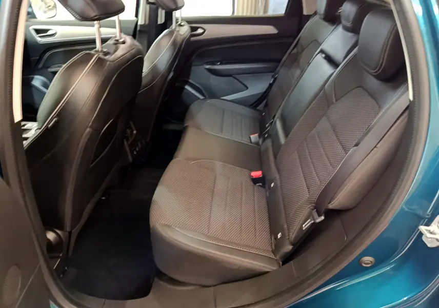 Vue côté droit sur l'intérieur arrière bleu du Renault Arkana 2023, mettant en valeur les sièges en tissu noir et les finitions modernes.