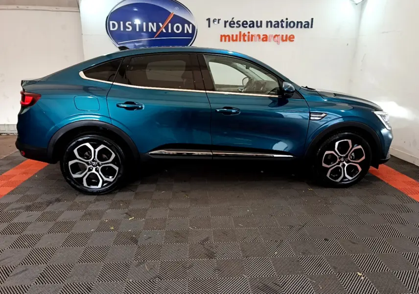 Profil droit d'un Renault Arkana bleu 2023, soulignant ses jantes alliage distinctives et sa silhouette coupé SUV.