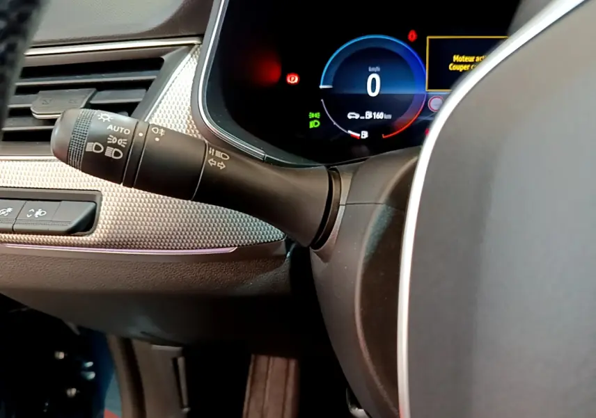 Gros plan sur la manette des feux et le tableau de bord numérique bleu du Renault Arkana Techno E-Tech 2023.