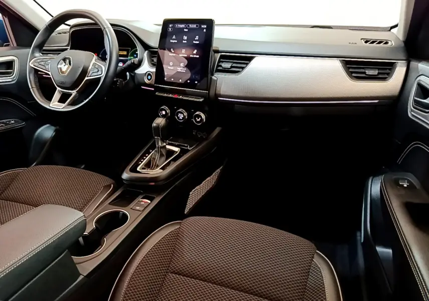 Vue intérieure avant droite du Renault Arkana 2023, tableau de bord moderne avec écran tactile vertical et volant cuir multifonctions.