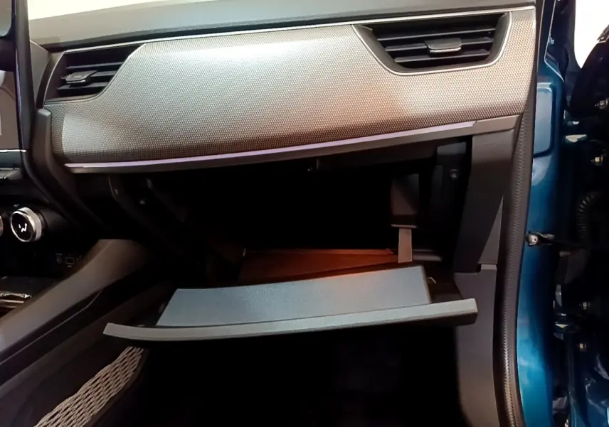 Vue intérieure côté passager du coffre à gants ouvert du Renault Arkana bleu, soulignant la texture du tableau de bord.