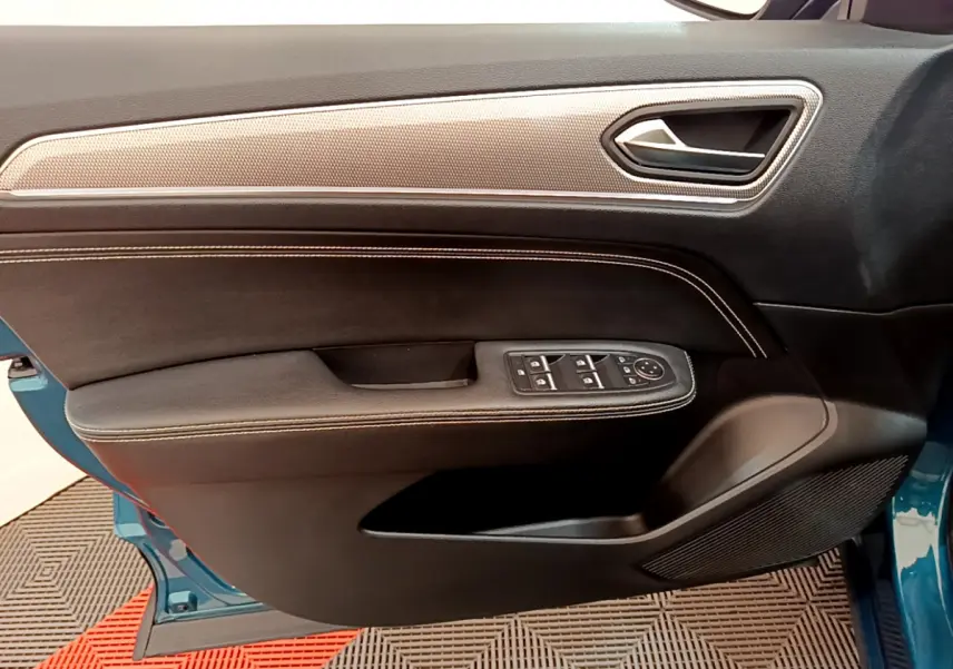 Vue intérieure côté gauche de la porte avant d'une Renault Arkana bleu 2023 avec commandes de vitres et garniture noire.