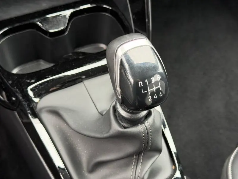 Gros plan sur le levier de vitesses manuel noir brillant de la Citroën C3 1.2 Turbo 100ch MAX, intérieur noir Perla Nera.