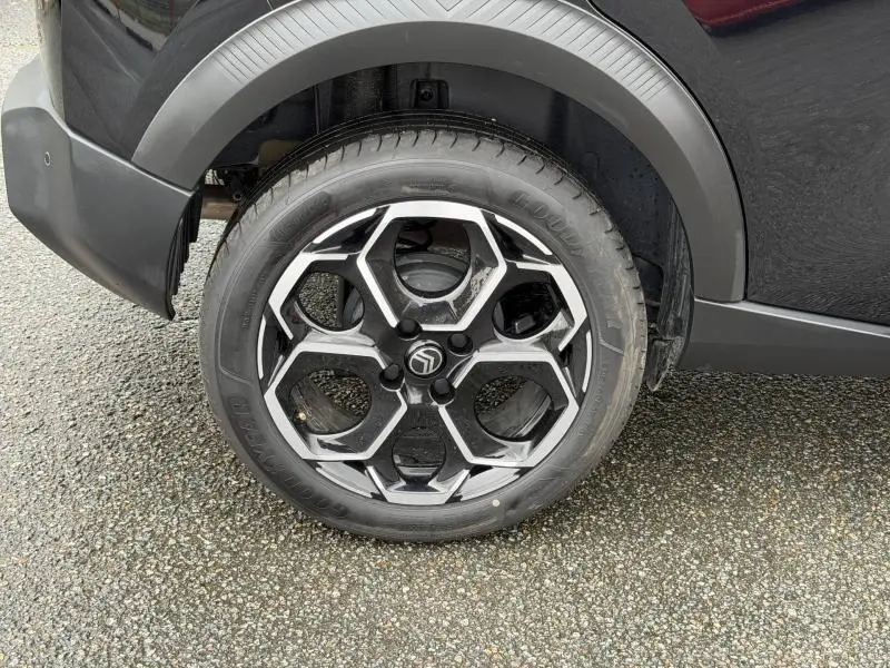 Gros plan sur la roue arrière droite d'une Citroën C3 2025 noire Perla Nera avec jante alliage au design hexagonal.