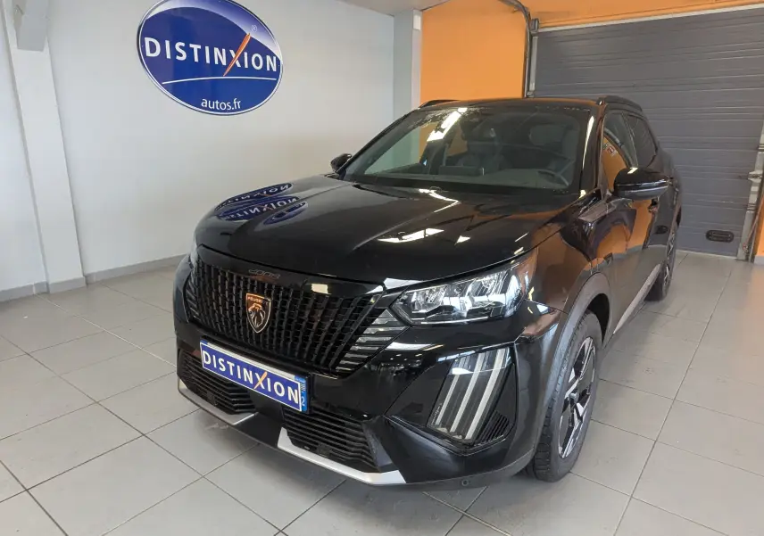 Peugeot 2008 noir 130ch eat8 allure vue 3/4 avant droit en intérieur avec calandre et phares LED distinctifs.