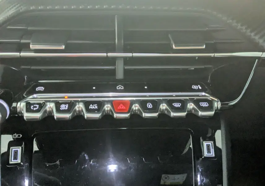 Gros plan sur la rangée de boutons de commande du tableau de bord du Peugeot 2008 noir 2024, version 130ch eat8 allure.