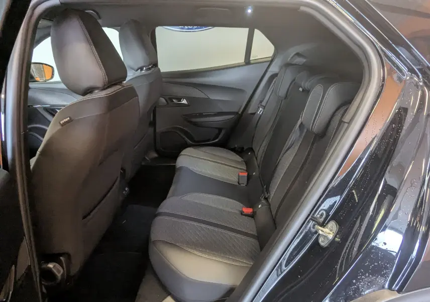 Vue intérieure côté droit montrant la banquette arrière en tissu gris et noir du Peugeot 2008 noir 2024 finition Allure.