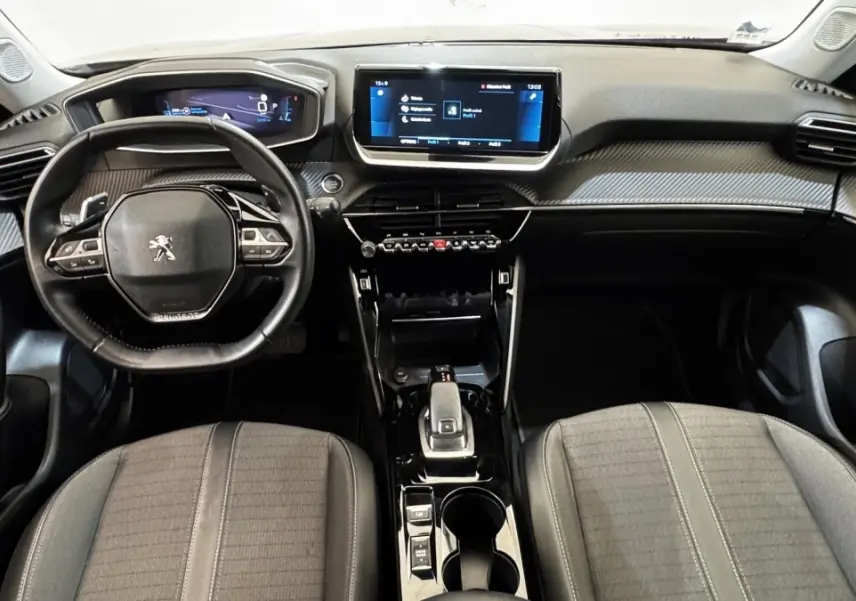 Vue intérieure frontale du poste de conduite gris foncé du Peugeot 2008 avec écran tactile central et volant compact multifonctions.