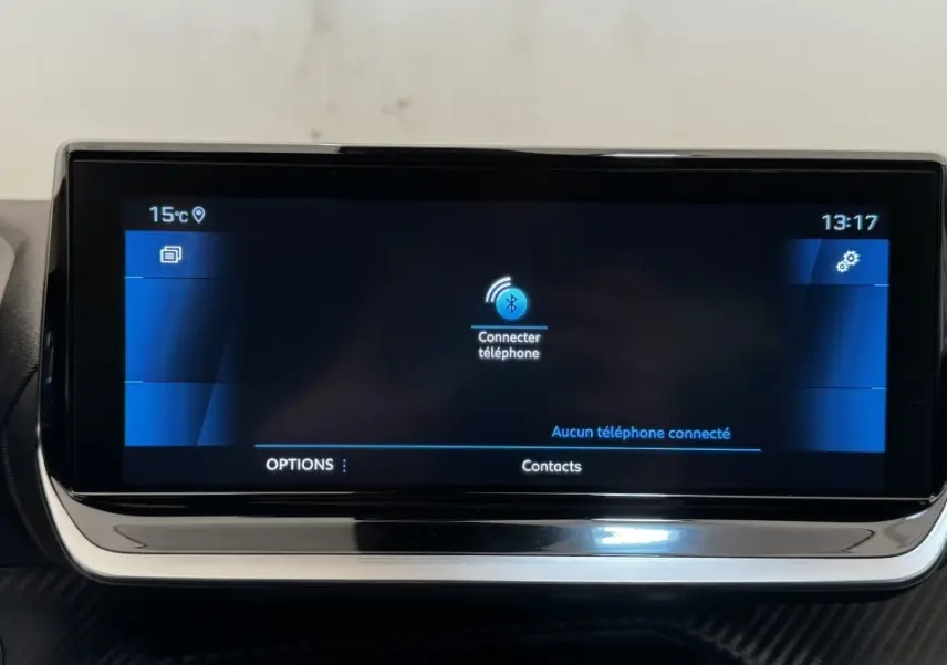 Écran tactile central du tableau de bord du Peugeot 2008 gris foncé, affichant la connexion Bluetooth au téléphone.