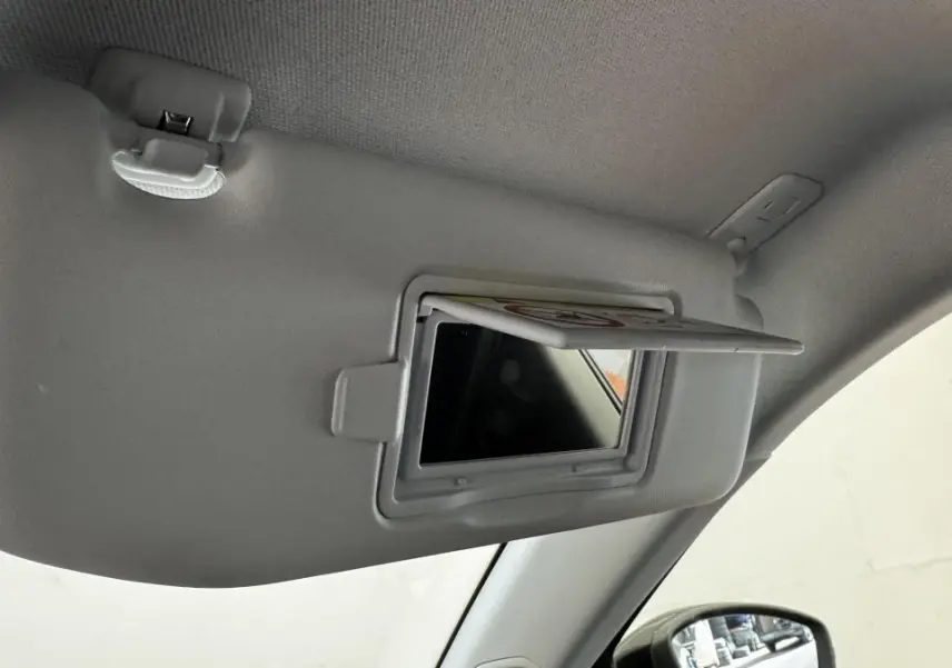 Détail du pare-soleil côté conducteur avec miroir de courtoisie ouvert dans l’habitacle gris clair d’un Peugeot 2008.