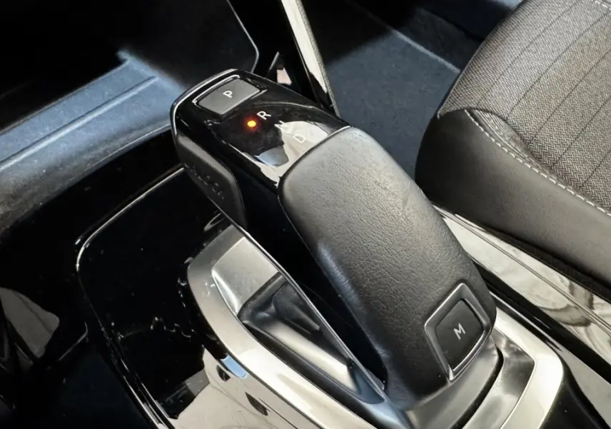 Le levier de vitesses automatique noir de la Peugeot 2008 gris foncé, vue rapprochée de l'intérieur côté console centrale.