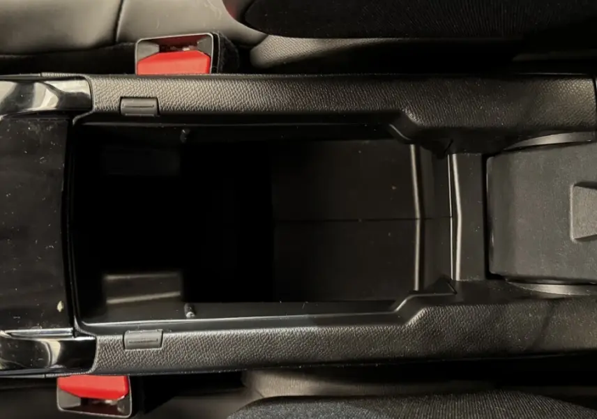 Vue plongeante sur le rangement central noir ouvert de la Peugeot 2008 PureTech 130 S&S EAT8 Allure Pack.