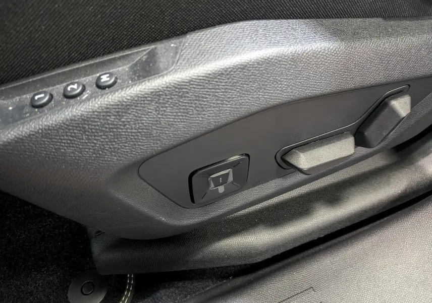 Gros plan sur les commandes de réglage électrique du siège côté gauche, intérieur noir du Peugeot 5008 Hybrid 2025.