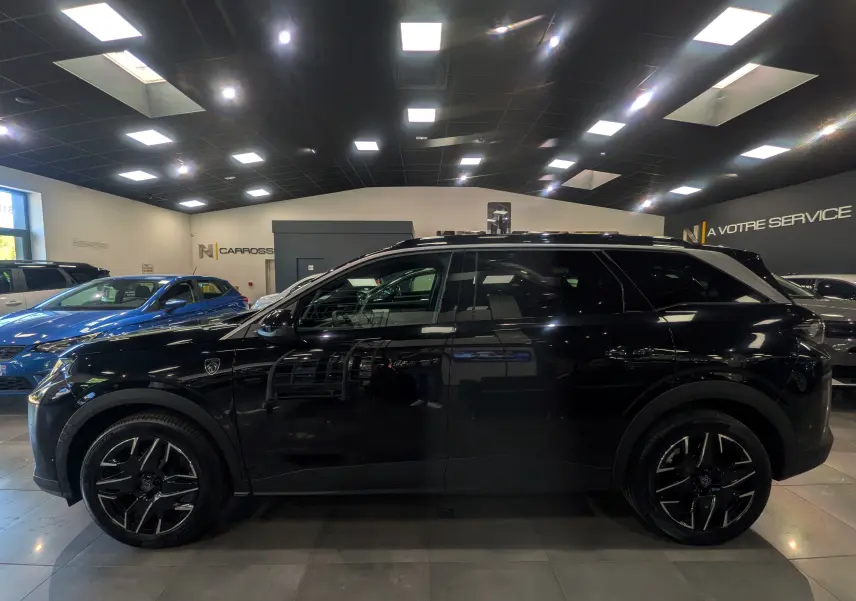 Peugeot 5008 Hybrid 145 GT noir Perla vue de profil côté gauche en intérieur, avec jantes noires et toit panoramique.